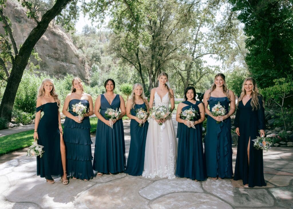 Lineup of 7 bridesmaids with bride in the middle all holding bouquets