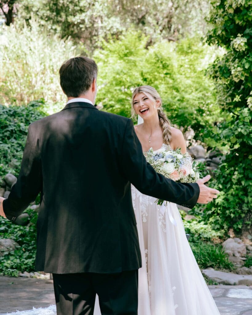 Bride smiling at her dad as they see each other for the first time on her wedding day