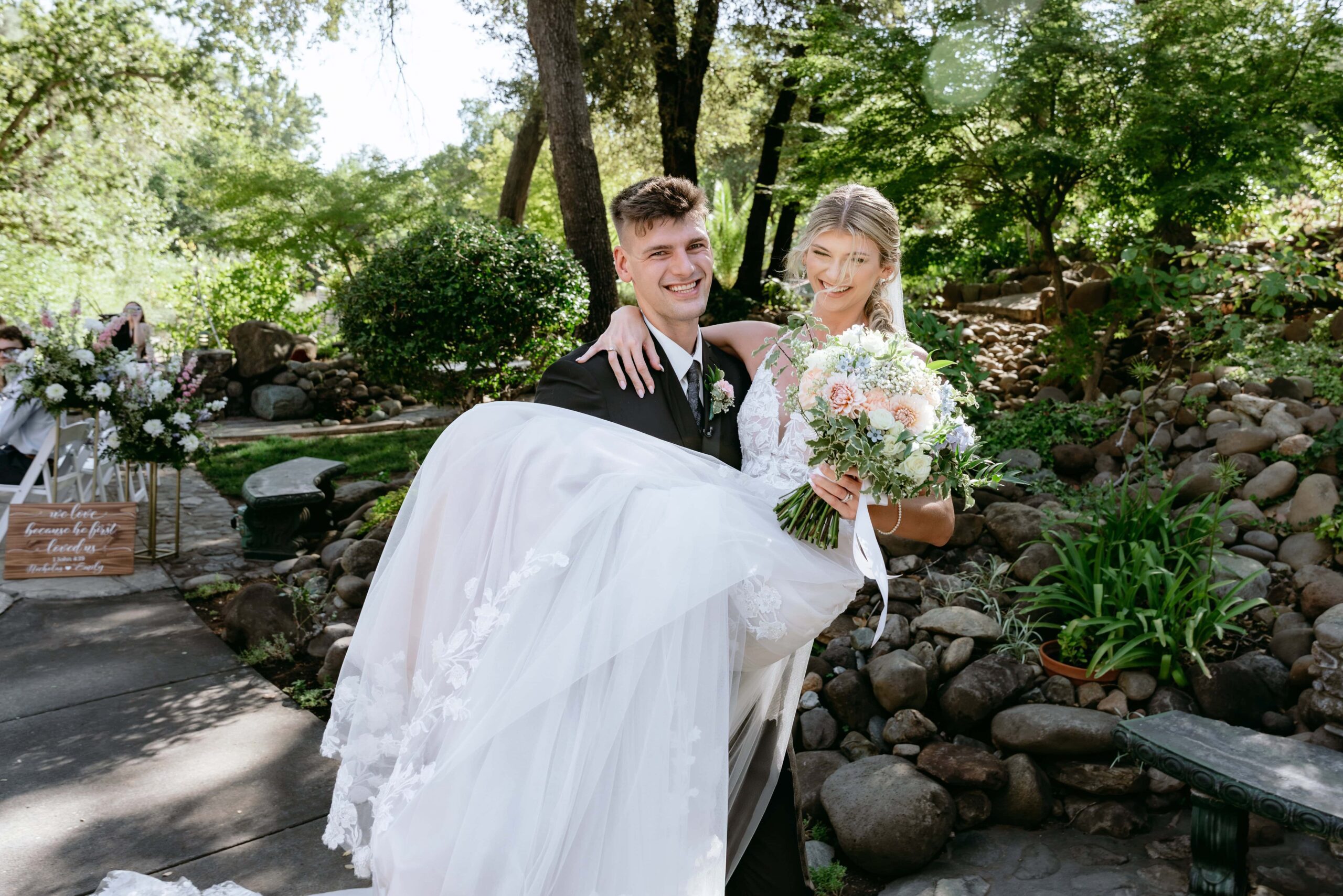 Groom picks up bride and carries her after their wedding ceremony in Northern California